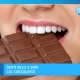 Bocca di donna con bei denti morde cioccolato